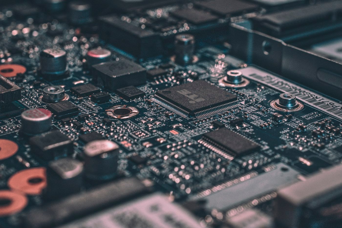 A close view of a circuit board with chips, capacitors, and solder points